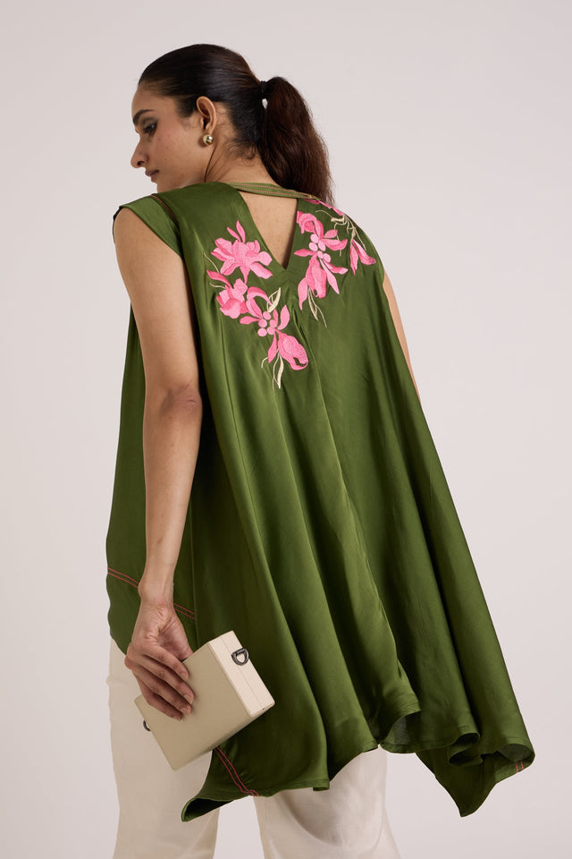 Olive Zuma top in motion, back view of the flowing trail hem with a clutch