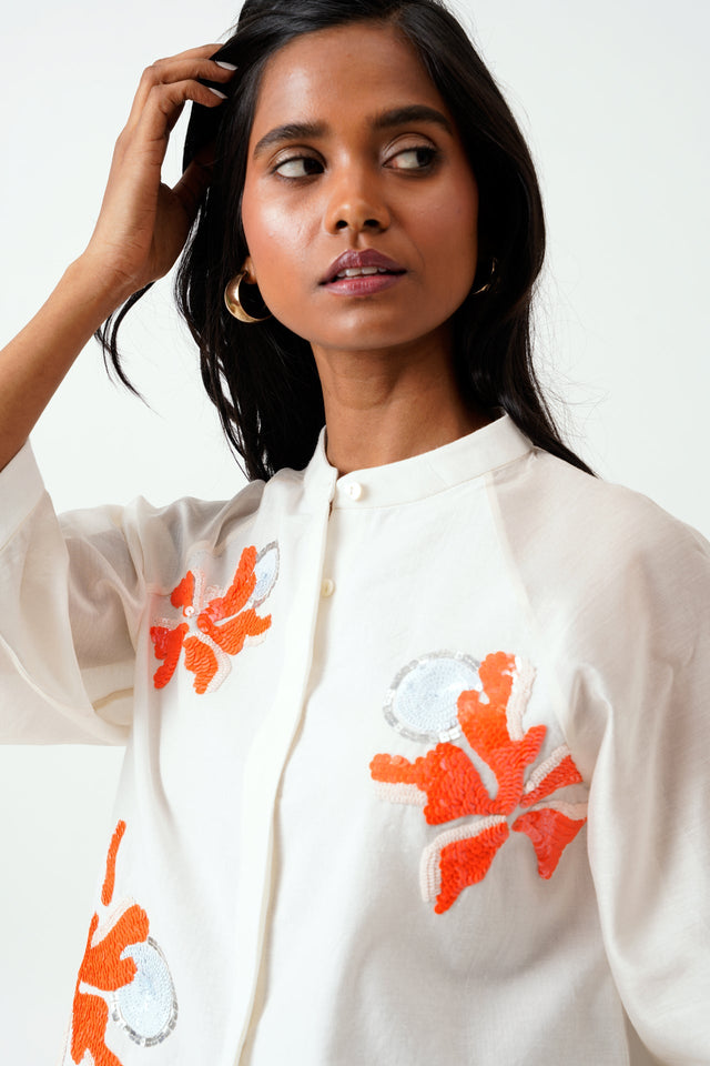 Close view of the Ivory Zola shirt band collar and orange floral applique
