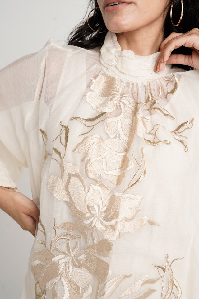 Close view of the Alba ivory tunic ruffled neckline and tonal floral embroidery