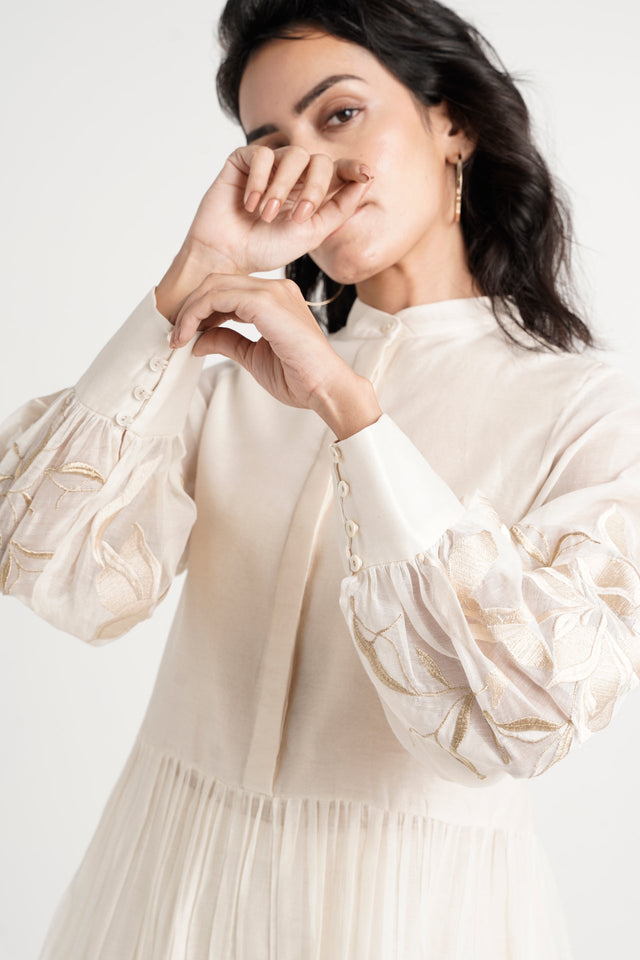 Ivory Abe 2.0 tunic with a hand raised, close front view of the embroidered balloon sleeves