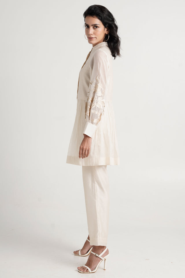 Ivory Abe 2.0 tunic set looking over the shoulder, side view of the gathered peplum