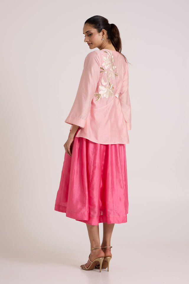 Jay pink Hira-Jun set looking over the shoulder, back view of the floral applique jacket