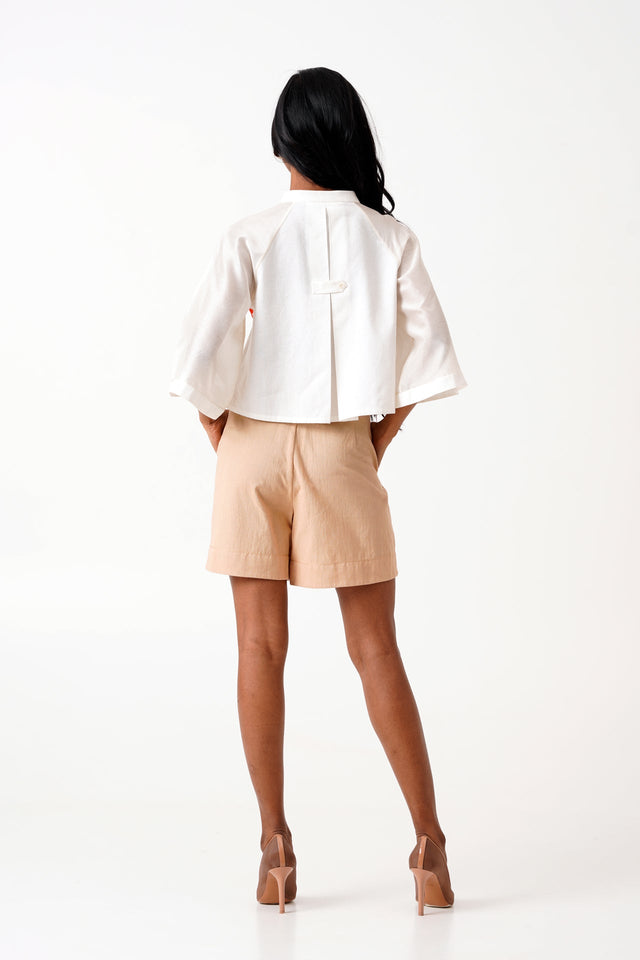 Ivory Zola raglan crop shirt and shorts, back view showing the box pleat