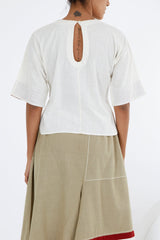 Ivory crop top back view showing the keyhole opening at the nape and dropped shoulders