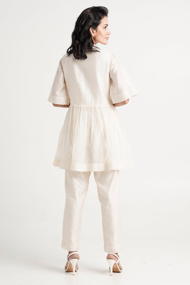 Ivory Abe 2.5 peplum tunic set, back view showing the gathered peplum and wide sleeves