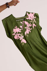 Close view of the Olive Zuma top V back and pink floral applique swinging on a hanger