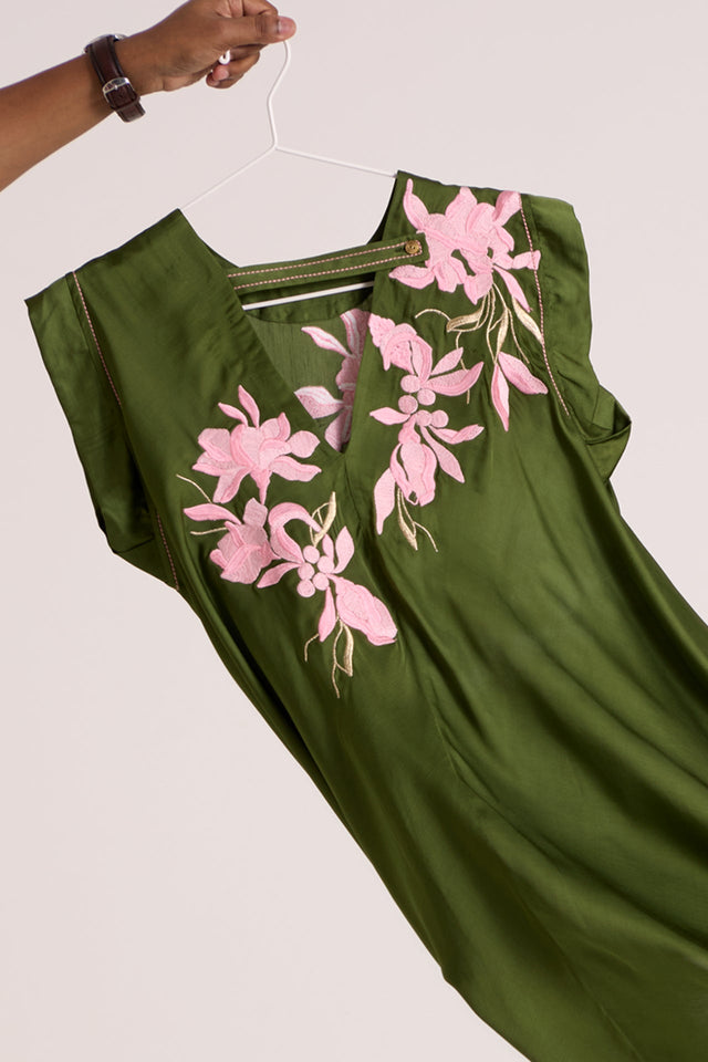 Close view of the Olive Zuma top V back and pink floral applique swinging on a hanger