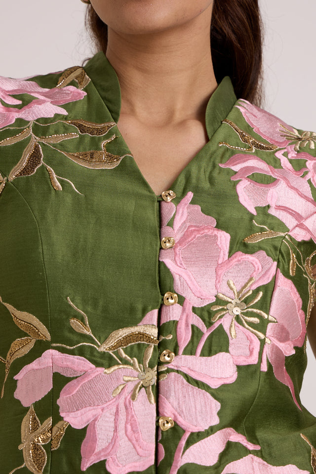 Close-up of the Stacy vest notched collar, gold buttons and pink floral applique