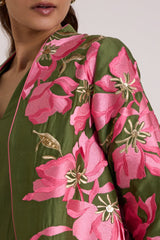 Close-up of the Rafiya jacket front edge with pink lilies, gold details and the V neck dress