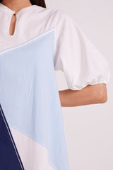 Close-up of the Juno dress keyhole neckline, puff sleeve cuff and contrast piping