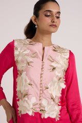 Close front view of the Cory dress blush bib with ivory floral applique and gold buttons