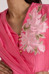 Close-up of the Velan top floral applique, gold buttons and draped wrap front
