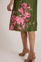 Close-up of the Vinny olive dress hem with pink lily applique and gold leaves