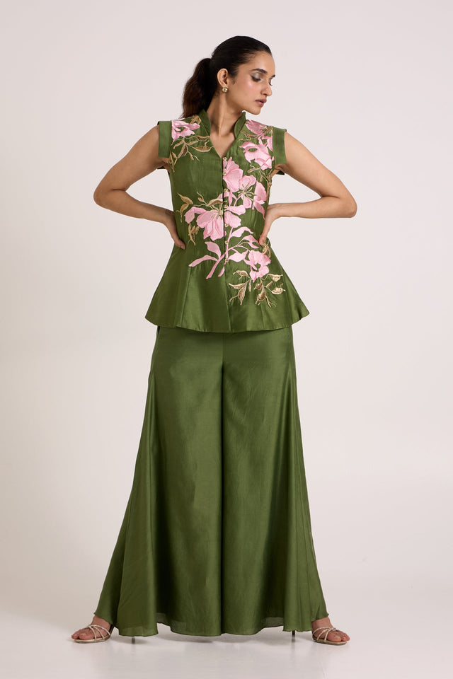 Olive Stacy peplum vest and flare pants with hands on the waist, full length front view