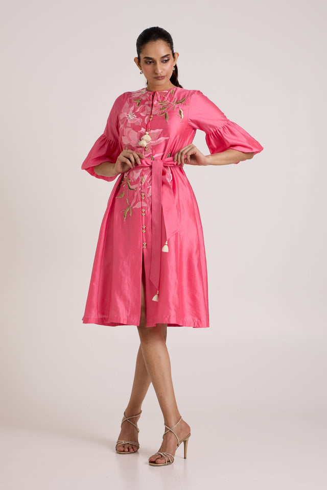 Jay pink Delphi midi dress with tie waist and flared sleeves, front view with a hand on the hip