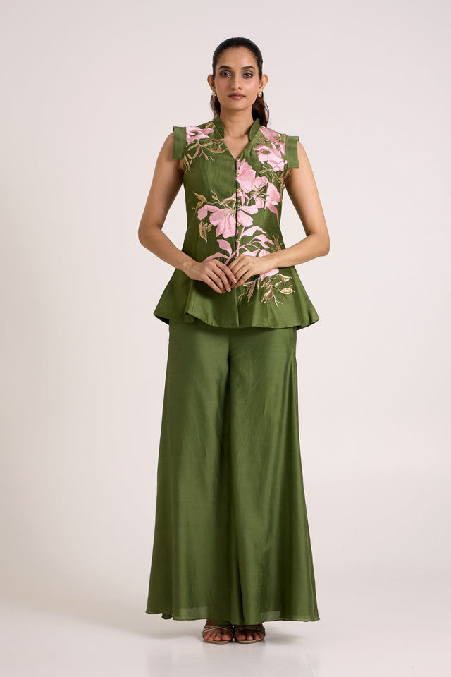 Olive Stacy set with arms relaxed, straight front view of the embroidered peplum vest