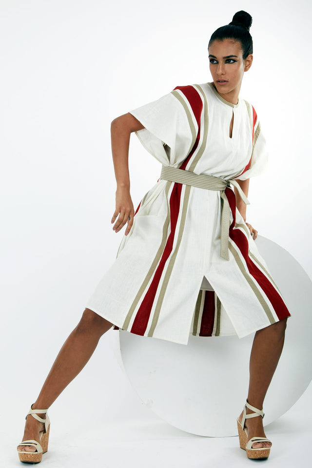 Fubu ivory kaftan dress with a hand on the hip, front view showing the keyhole neck and belt