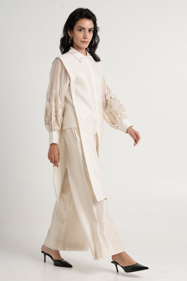 Buckler ivory hostess kurta set walking with black heels, full length three quarter view