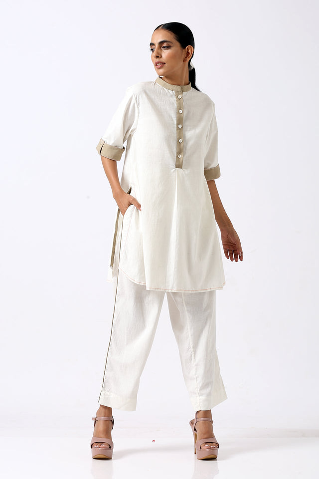 Ivory Sabah mandarin collar tunic set with hands in pockets, three quarter front view