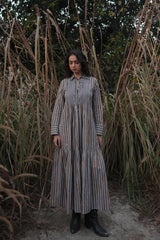 Model wearing the Akari Striped Dress in Brown by MAGO, long tiered shirt dress with collar, front view