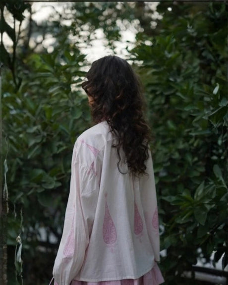 Model wearing the white Bella Top with pink block print, side back view
