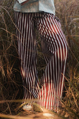 Close-up of the burgundy and white striped Dusk Pants wide legs, front view