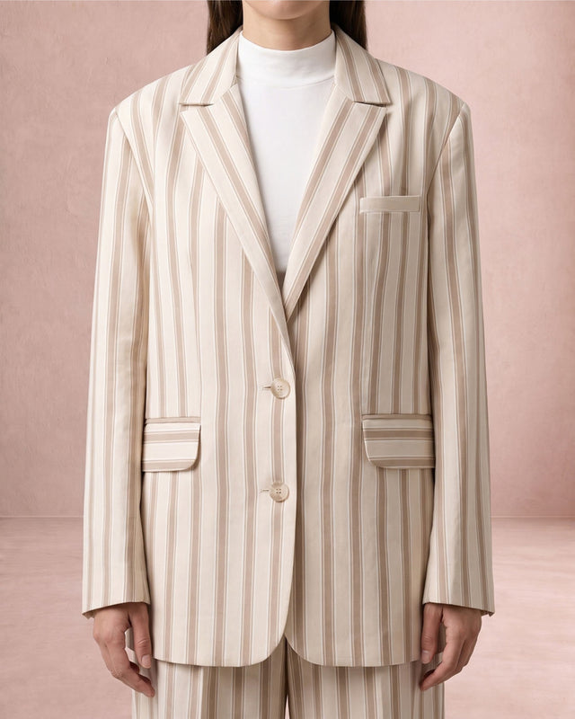 Model seated in the beige striped Rekh Double-Buttoned Blazer, front view