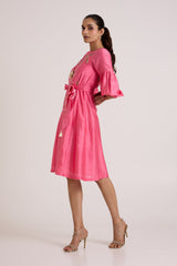 Jay pink Delphi floral midi dress with hands behind the back, side view