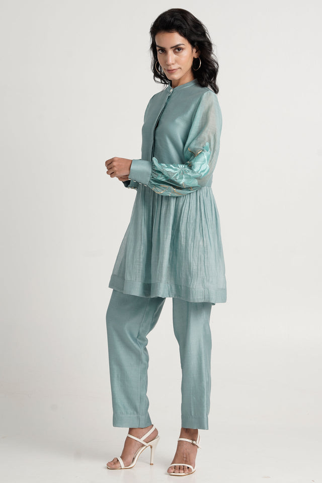 Aqua Abe 2.0 peplum tunic and straight pants with white heels, three quarter view