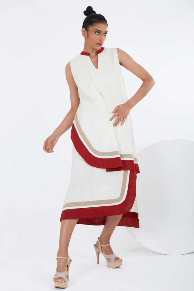 Sachi ivory midi dress with asymmetric layered panels and red binding, three quarter view