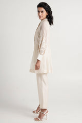 Ivory Abe 2.0 tunic set looking over the shoulder, side view of the gathered peplum