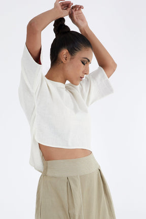 Ivory Crop Top by Madder Much, relaxed boxy crop top with elbow sleeves and curved hem, side view with arms raised