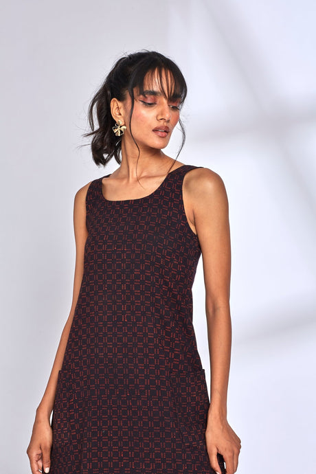 Close-up of the Aura Black Dress scoop neckline and red block print