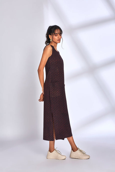 Side view of the Aura Black Dress showing the side slit and white sneakers