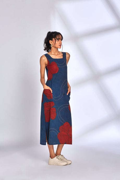 Model wearing the Aura Indigo Dress with hand in pocket and white sneakers, side view