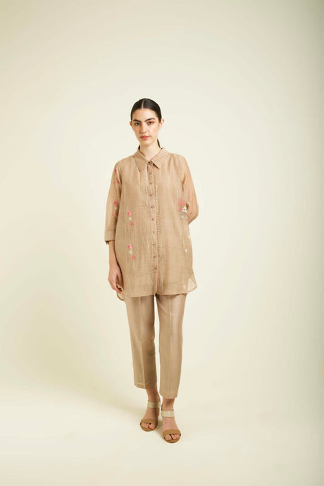 Model wearing the beige Mul Chanderi Shirt with pink floral embroidery and straight pants, front view