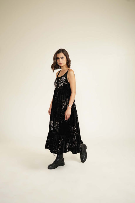 Black tiered midi dress with discharge floral print, model walking side angle view