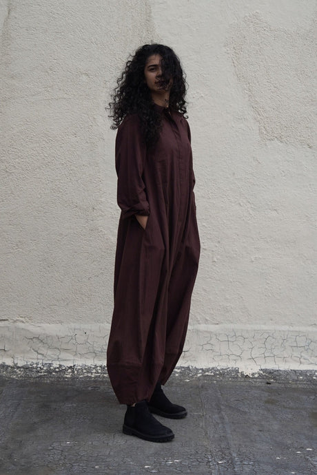 Side view of the dark brown collar sleeve Suga jumpsuit with pockets