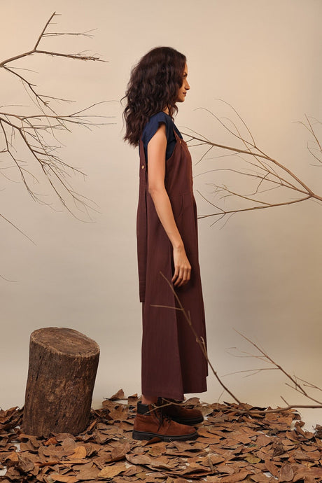 Side view of the brown button strap dungarees with long wide legs