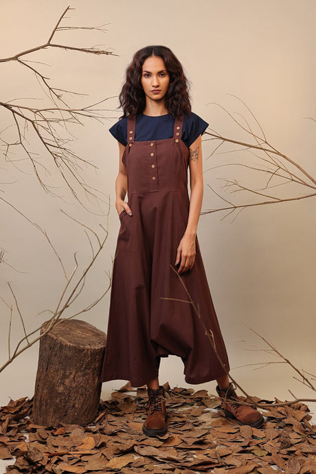 Brown Dungarees from MATI, brown button strap dungarees with drop crotch worn over a navy top, front view