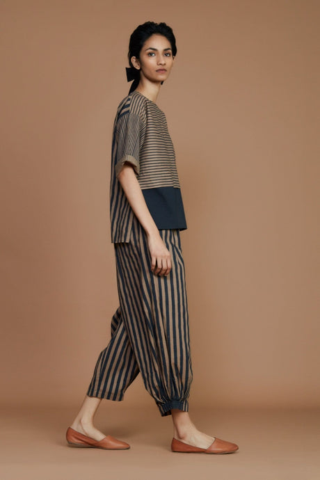 Side view of the Brown with Charcoal Striped CB Ekin Top styled with matching striped tapered pants