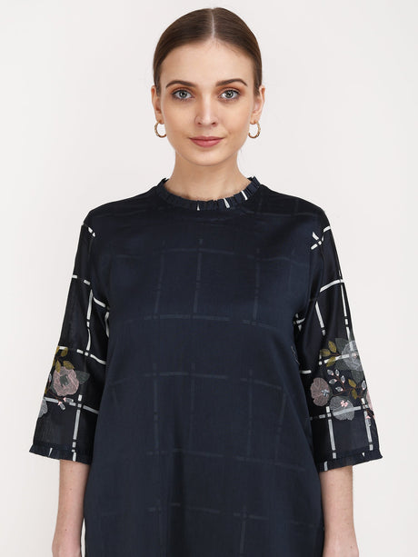 Close-up of the navy Checks & Roses Tunic neckline and embroidered checked sleeves