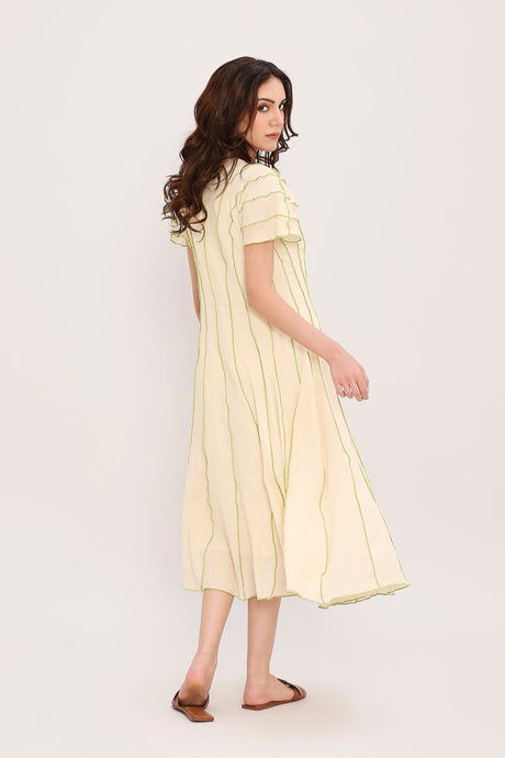 Back angled view of the cream Coco moss panelled dress with flared skirt