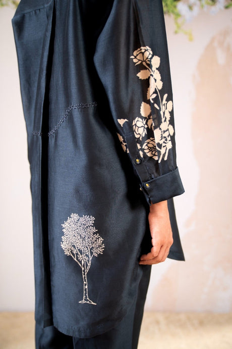 Close-up of the navy shirt sleeve with ivory floral print and tree motif