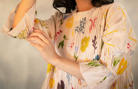 Close-up of the pink Chanderi tuck dress pintucked bodice and painted flowers