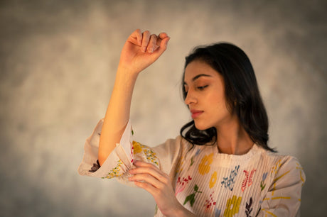 Close-up of the pink Chanderi tuck dress sleeve and floral print, arm raised