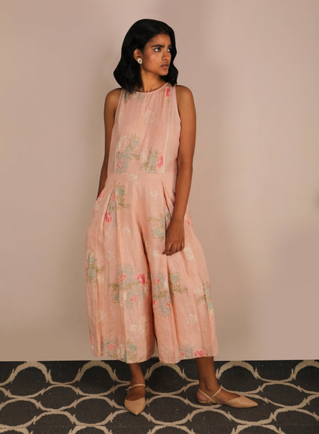 Model wearing the peach rose print jumpsuit with round neckline, three-quarter view