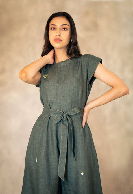 Model wearing the forest green jumpsuit, half length view showing embroidery and belt