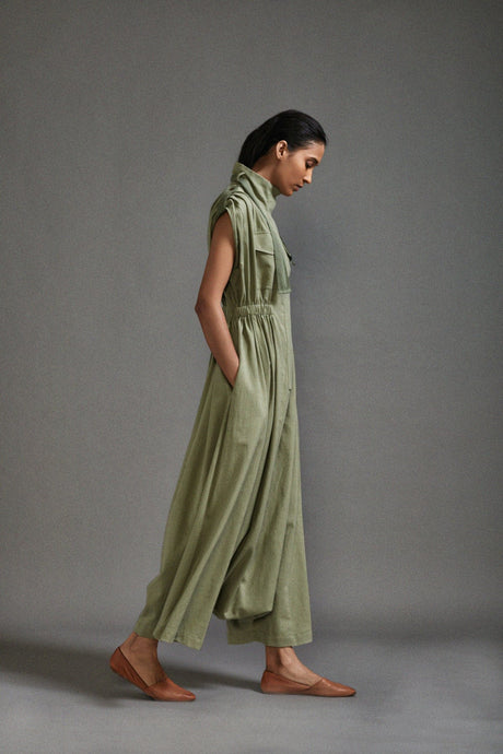 Side view of the Green Safari Sphara Jumpsuit walking, showing the dropped crotch wide legs