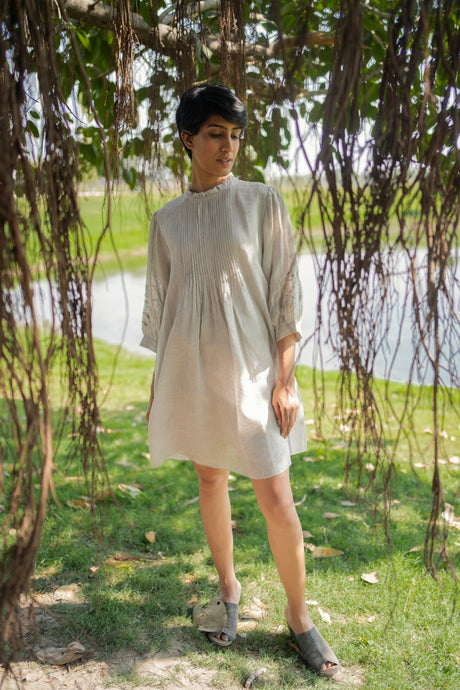 Model wearing the Grey Applique Dress from ARCVSH by Pallavi Singh, pale grey knee-length dress with pintuck yoke, front view